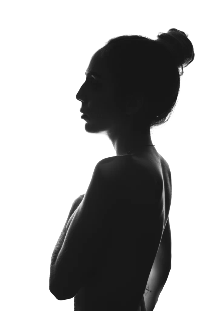 Silueta femenina en perfil sobre fondo blanco, representando evaluación previa a procedimiento quirúrgico estético en Clínica Avellaneda